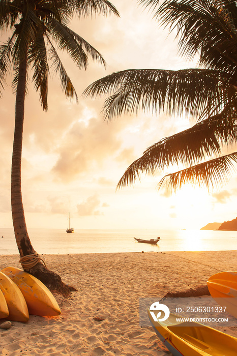 Seascape with kayaks on the sunset beach.