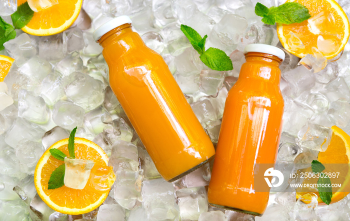 Carrot smoothie in glass bottle with fresh oranges on ice