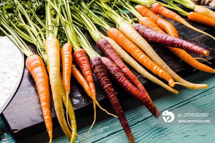 top view of various fresh carrots on wooden surface