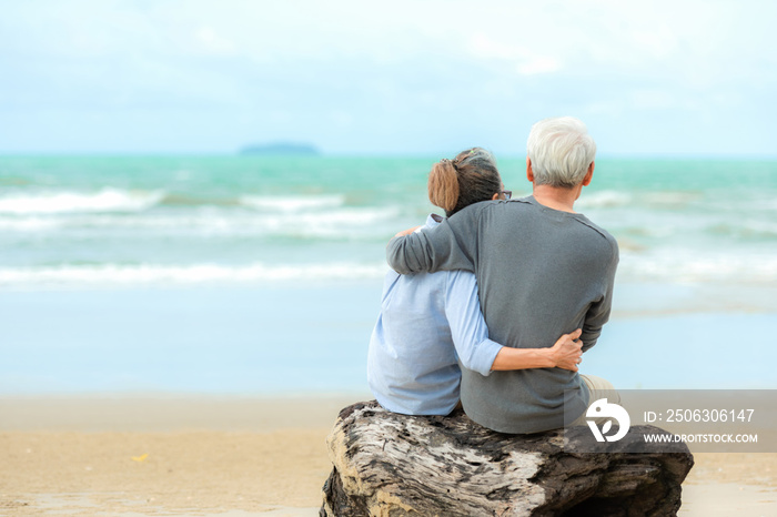 Asian Lifestyle senior couple hug and sitting on the beach happy in love romantic and relax time.Â  