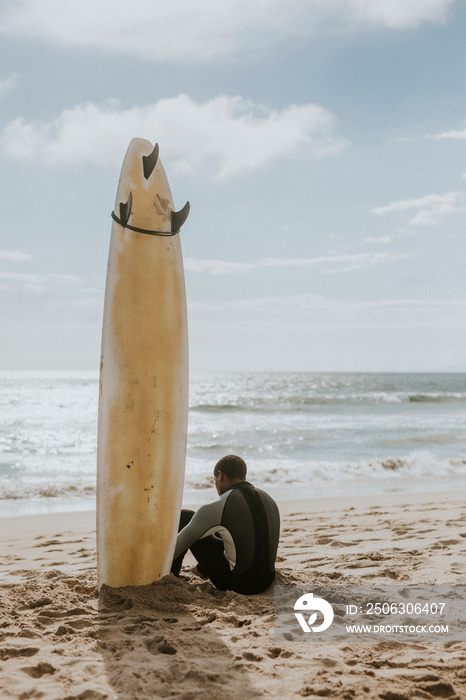 Surfer resting on the beach