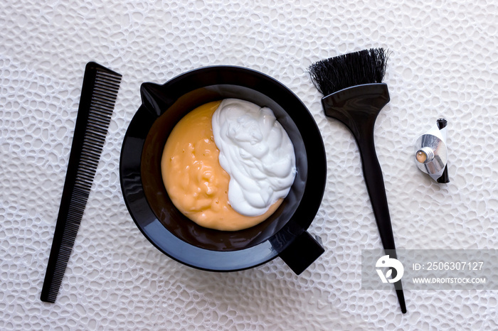 Mixing hair dye in a special plastic bowl. Concept is hair coloring.