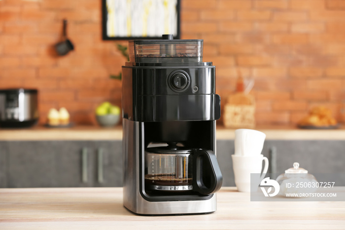 Modern coffee machine on table in kitchen