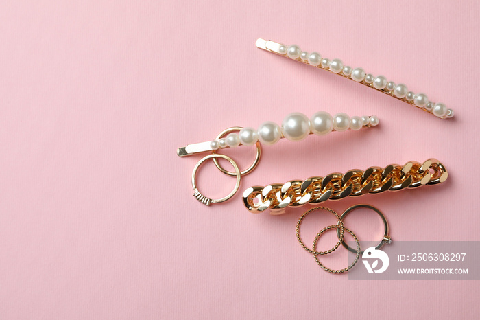 Hair clips and rings on pink background