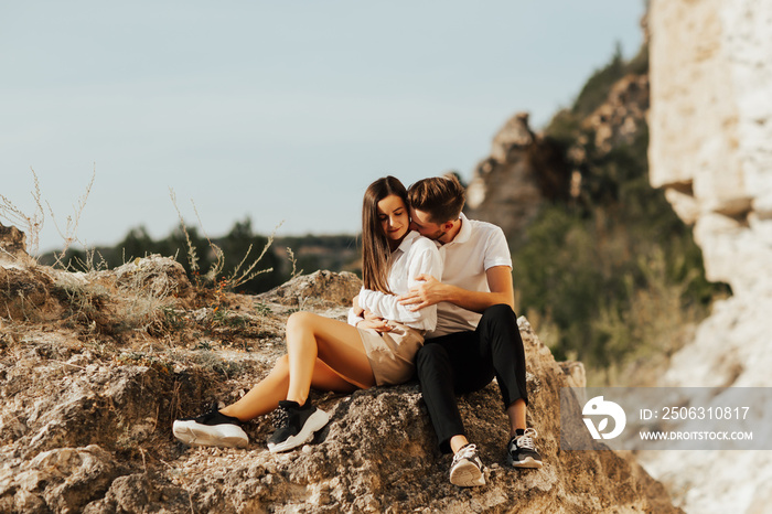 Romantic kiss of a couple in the mountain. Man kisses his girlfriend gently on the neck. 