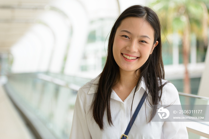 年轻漂亮的亚洲女商人在人行天桥上