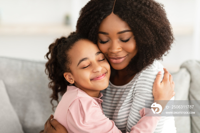 Closeup portrait of black mother and daughter hugging