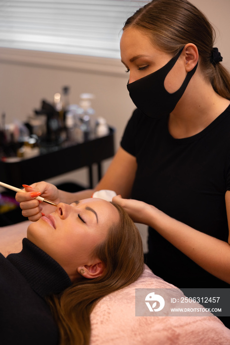 Eyelash extension procedure with master and a client in a beauty salon