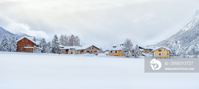 Winter panorama of the snowy landscape at the evening with cosy buildings in Surlej village in Switz