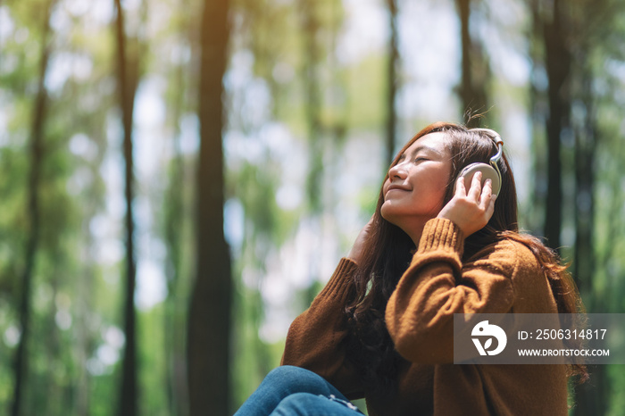 A beautiful asian woman enjoy listening to music with headphone with feeling happy and relaxed in th