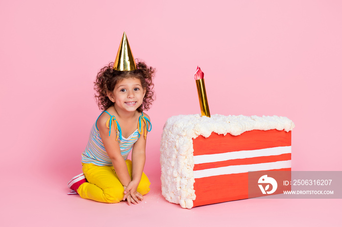 Portrait of attractive cheerful wavy-haired girl sitting near festal cake having fun festive isolate