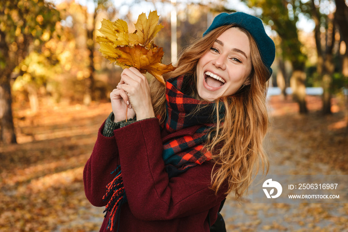 Cheerful young girl with long brown hair wearing autumn