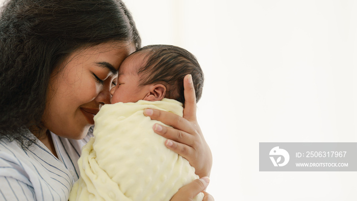 mixed race african american and asian mother holding newborn baby