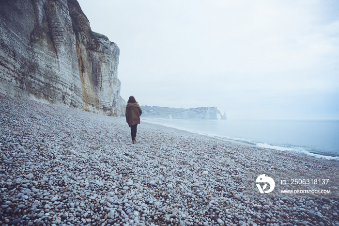 a lonely girl walks along the ocean