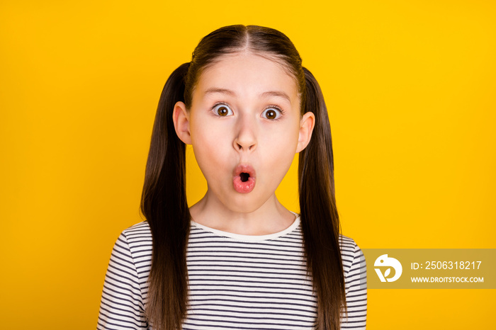 Photo of young school girl amazed shocked surprised fake novelty news isolated over yellow color bac