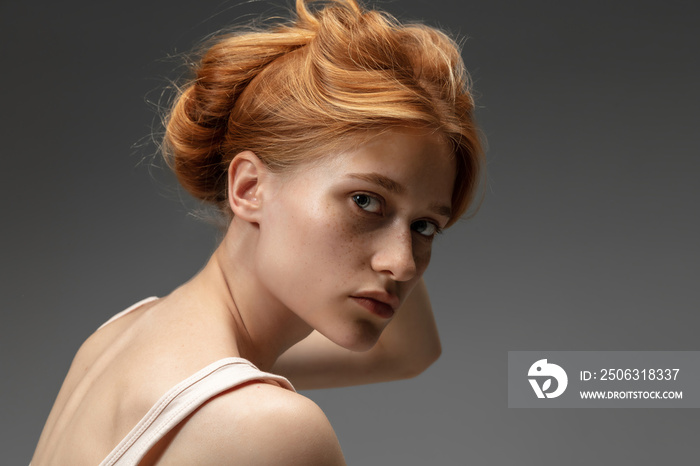 Tender. Fashion portrait of beautiful redhead woman isolated on grey studio background. Concept of b