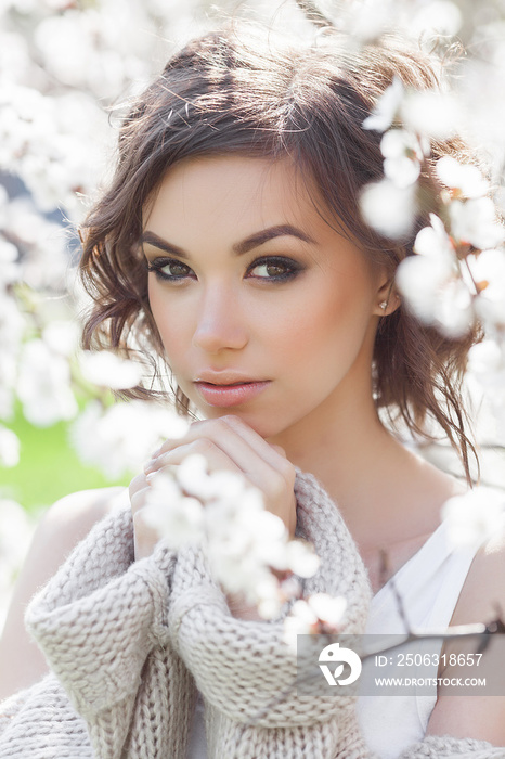 Close up portrait of young beautiful woman on spring background. Attractive young girl with flowers.