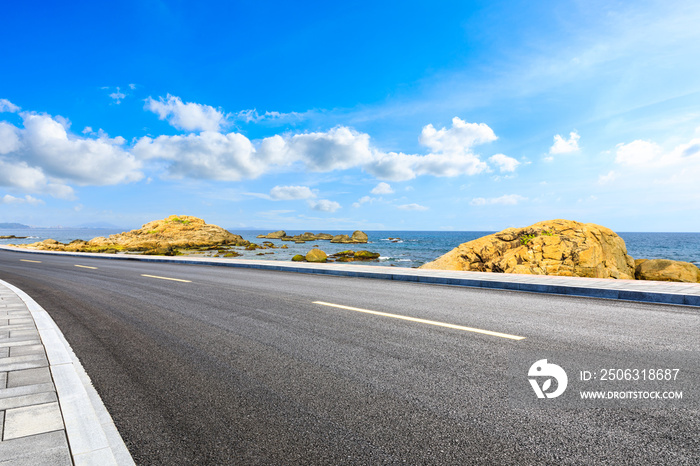 Asphalt road and beautiful seaside scenery under blue sky.