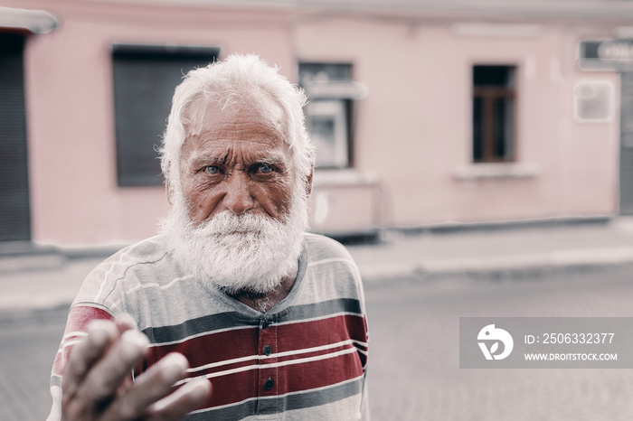 gray old grandfather points with his finger and looks thoughtfully into the distance.