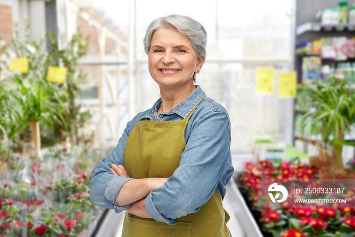 gardening, farming and old people concept - portrait of smiling senior woman in green garden with ap