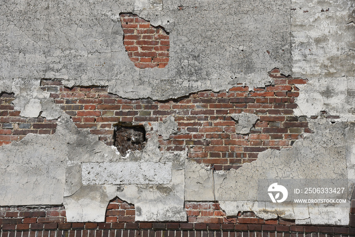 enduit de façade craquelé avec fissures et briques apparentes