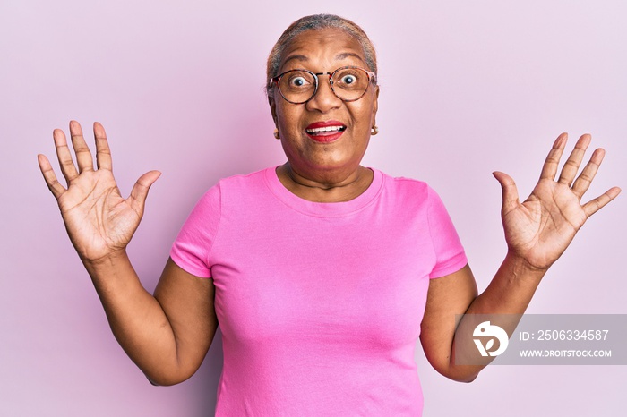 Senior african american woman wearing casual clothes and glasses celebrating mad and crazy for succe