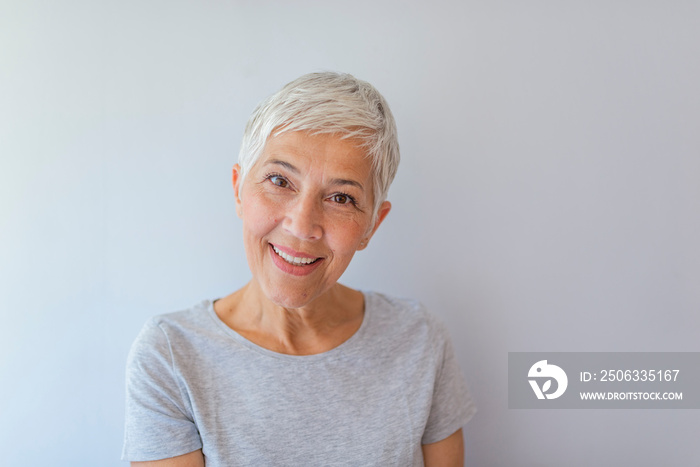 Portrait of beautiful senior woman in front of grey background. Portrait of a beautiful elderly woma