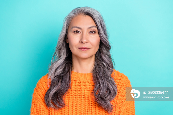 Portrait of attractive content calm grey-haired woman wearing orange pullover isolated over bright t