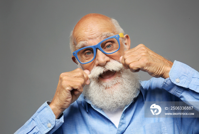 Elderly man in  stylish clothes on grey background