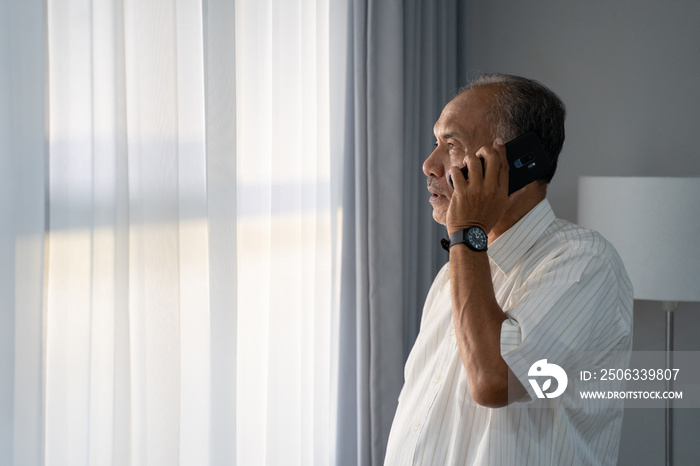 senior asian man calling with smartphone at home