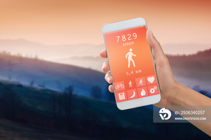 Health monitoring concept - special app on smartphone in a hand outdoors, landscape background