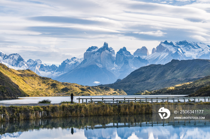 Beautiful panoramic view small people standing at the dock from the lake with Cuernos, horn mountain