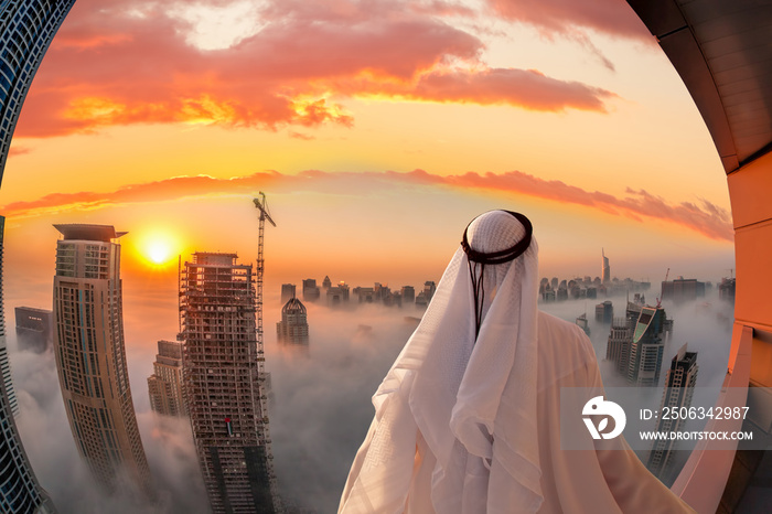 Arabian man is watching Dubai marina in Dubai, United Arab Emirates.