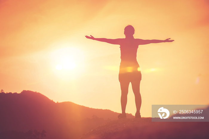 Copy space of woman rise hand up on top of mountain and sunset sky abstract background.