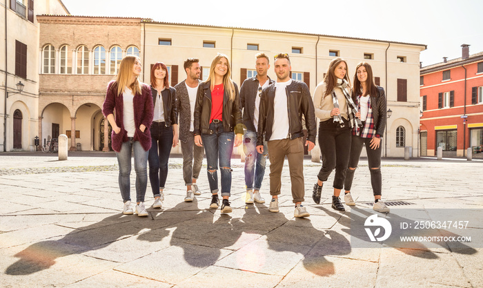 Group of best friends walking and talking in city center - Tourist guys and girls having fun around 