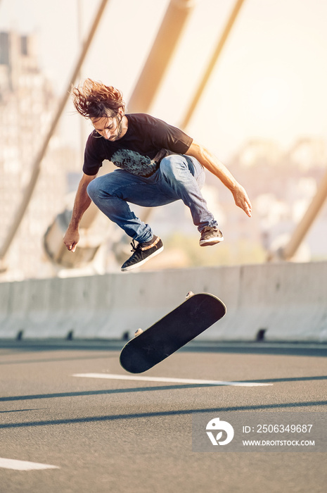 滑板运动员在城市交通中的街道公路桥上表演技巧和跳跃。自由骑行滑板