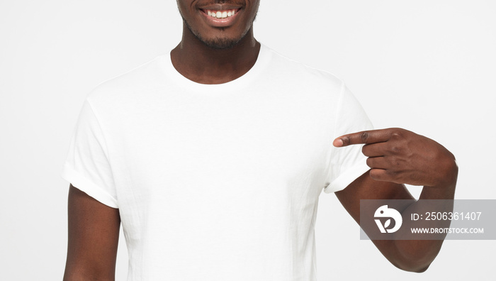 Young african american man pointing with index finger at blank white t shirt with empty space for yo