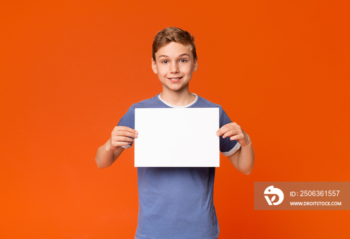 Cute smiling boy holding white blank placard