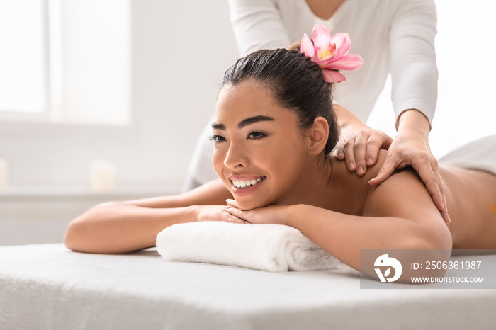 Professional massage advertisement concept. Young woman getting classical body therapy with organic 