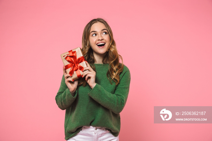 Happy blonde woman wearing in green sweater holding gift box