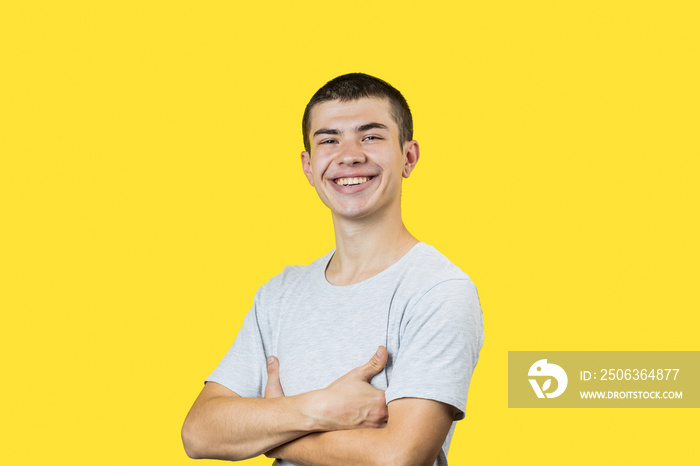 happy smiling caucasian 20 years old man over yellow background. casual clothes. copy space. studio 