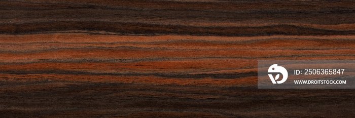 Unique ebony veneer background in brown color. Natural wood texture, pattern of a long veneer sheet,