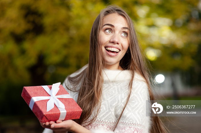 Portrait of a happy smiling girl holding present box