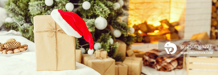 New Years gifts under the Christmas tree. The gifts are packed in kraft paper and tied