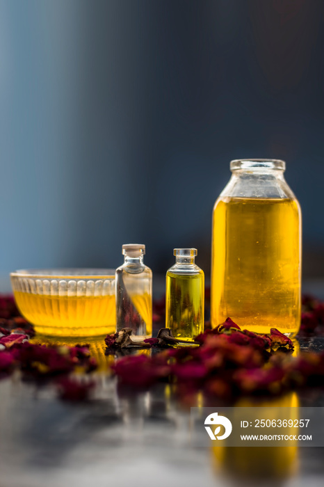 Close up of castor oil, tea tree oil, and some coconut oil in bottles on the wooden surface along wi