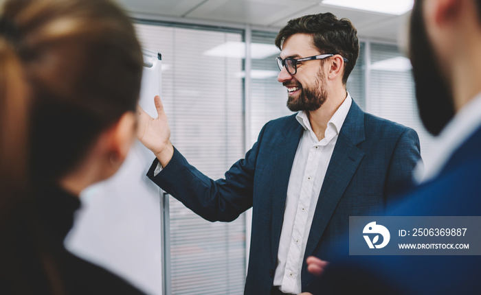 Cheerful entrepreneur presenting business plan to colleagues