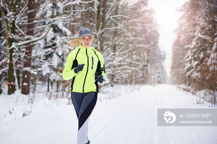 Front view of woman running in winter forest