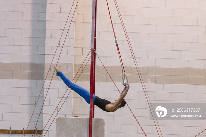 Male gymnast performing on gymnastic rings