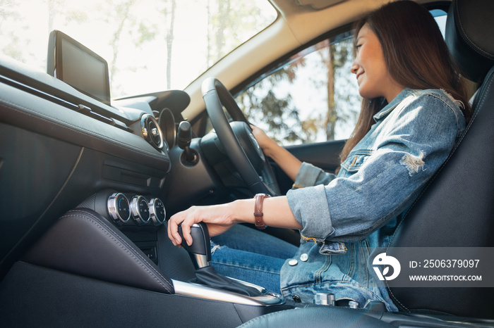 Closeup image a female driver shifting automatic gear stick while driving car