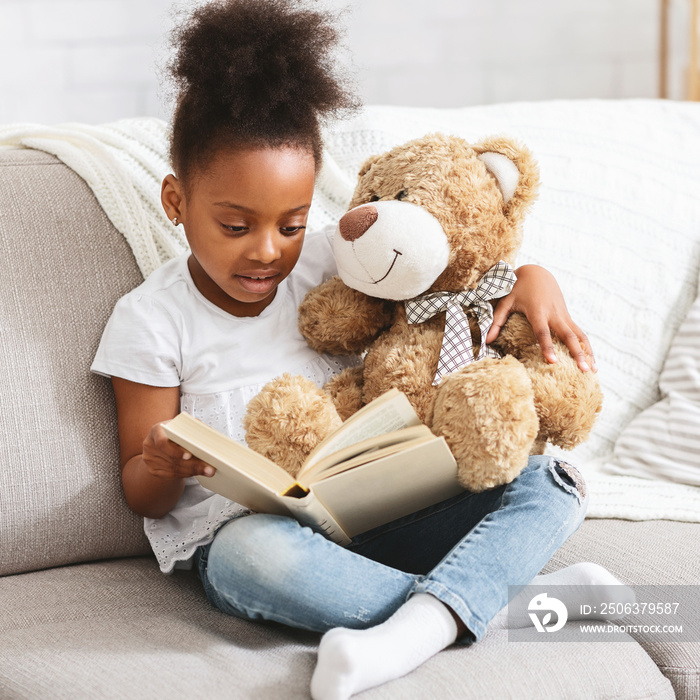 可爱的带泰迪熊的黑人孩子读书书